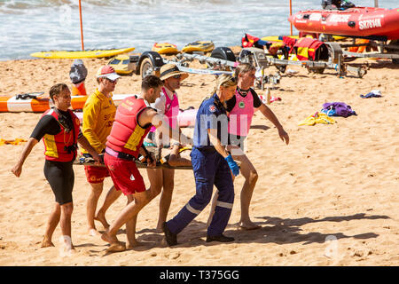 Ein in der Nähe von ertrinken Opfer durchgeführt aus Palm Beach auf einer Bahre durch Surf rescue Volunteers und Rettungsdienst Sanitäter, Sydney, Australien Stockfoto