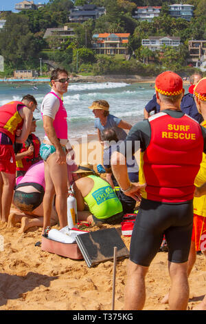 Man Rock Fishing wurde gerettet und befürchtet ertränkt in Palm Beach Sydney, Surf Rettung Rettungsschwimmer und andere sorgen für Sauerstoff und Wiederbelebung, bis der Krankenwagen eintrifft. Stockfoto