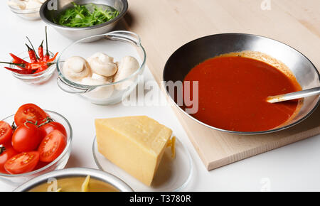 Pizza Zutaten zum Kochen. Käse, Champignons und Sauce in Schalen Stockfoto