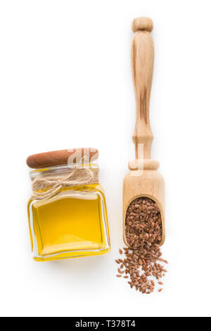 Leinöl in Flasche und Schaufel mit Leinsamen auf weißem Hintergrund, Ansicht von oben. Ätherische Öle Konzept Stockfoto