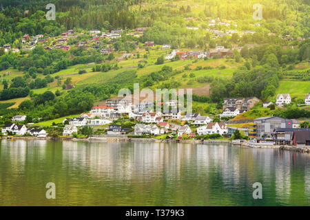 Dorf Häuser auf den Berghängen. Ein kleines Dorf mit modernen Häuser am See. Umweltfreundliche Lebensraum. Stockfoto