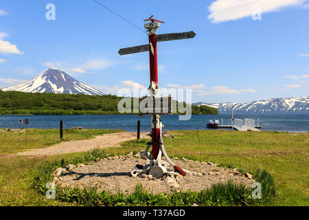 Kamtschatka, Russland - Juli 7, 2018: Richtung Schild in der Nähe von Kurile See vor dem Hintergrund des Vulkans Ilyinsky, Kamtschatka Stockfoto