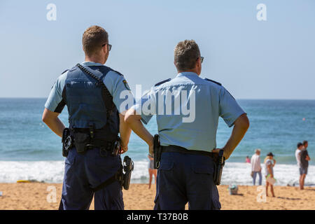 Zwei New South Wales Polizisten sehen Sie ein Surf Rescue Recovery auf Palm Beach, Sydney, Australien Stockfoto