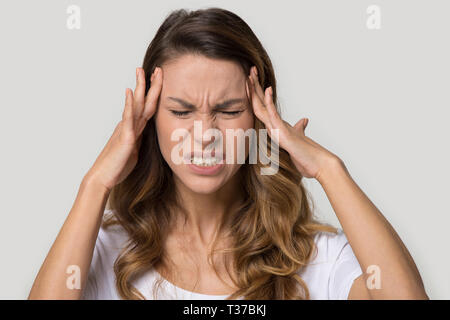 Closeup studio Portrait Junge weibliche Note Tempel leidet unter Kopfschmerzen. Stockfoto