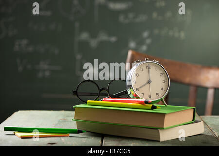 Zurück zu Schule Hintergrund mit Büchern und Wecker über Tafel. Zurück zum Konzept der Schule Stockfoto