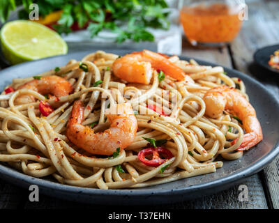 Asiatische Nudeln udon mit Garnelen, Gewürz, auf der Platte. Nahaufnahme. Chinesische/Japanische Nudeln Stockfoto