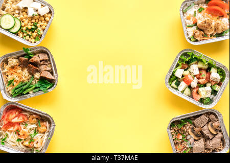 Täglichen Mahlzeiten in Folie Kästen auf gelben Hintergrund, Ansicht von oben, kopieren. Gesundes Essen Lieferung Konzept. Fitness Ernährung für Ernährung. Stockfoto