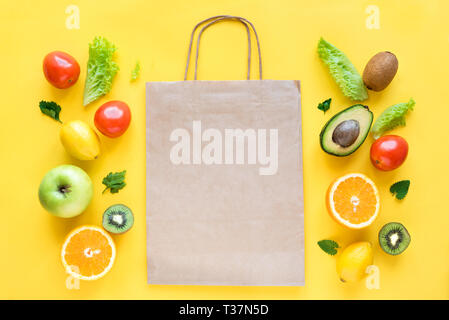 Gesundes essen Hintergrund. Gesunde Ernährung und Papiertüte Gemüse und Früchte auf Gelb, kopieren. Shopping Lebensmittel Supermarkt Konzept. Stockfoto