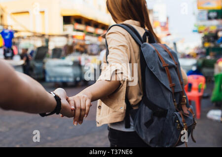 Junge Freundin die Hand des Freundes. Touristen backpacker Paar in Street Market in Bangkok, Thailand. Mir Konzept folgen Stockfoto