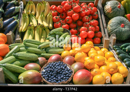 Schöne Komposition verschiedener frisch und reif, biologisches Obst und Gemüse in Kisten aus Holz, in einem Markt Stockfoto