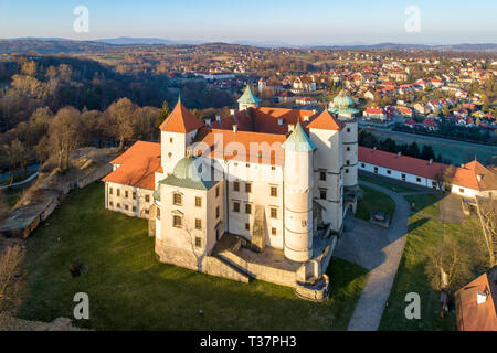 Polen. Renaissance, Barock Schloss mit einer Kapelle auf dem Hügel in Nowy WiÅ' Nicz. Die derzeit vom polnischen Staat gehört. Luftaufnahme im Frühjahr. Sunrise Stockfoto