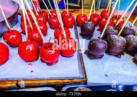 Schokoladenäpfel auf einem Stock, valencianische Süßigkeiten verkaufen auf einem Straßenstand, Karamelläpfel Stockfoto