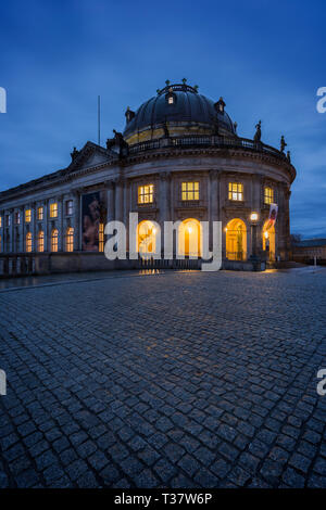 Wunderschöne Aussicht auf eine leere Brücke vor beleuchtete Bode-Museum auf der Museumsinsel in Berlin, Deutschland, in der Dämmerung. Stockfoto