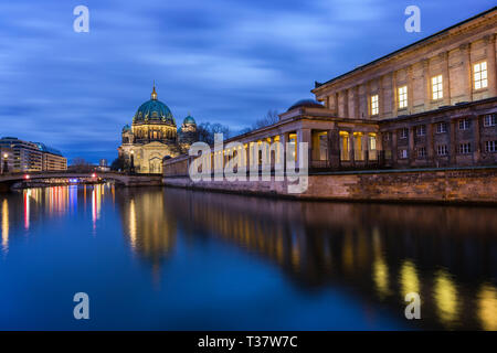 Wunderschöne Aussicht auf den Berliner Dom (Berliner Dom) und die Alte Nationalgalerie auf der Museumsinsel beleuchtet und Reflexionen auf der Spree in Berlin in der Abenddämmerung. Stockfoto