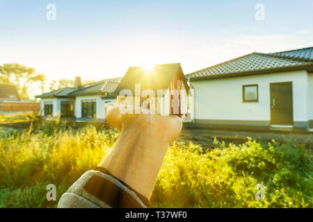 Modell Haus Hand - vor dem Hintergrund der Baustelle statt. Stockfoto