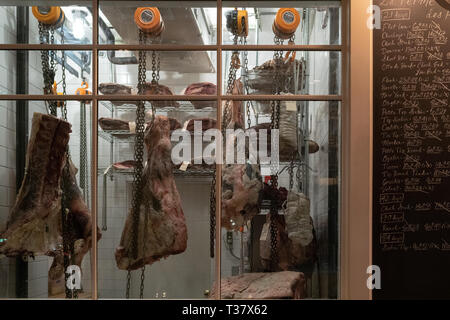 Seattle, Washington - 2019-02-24 - Kühlschrank im Restaurant Le Boeuf altern Rindfleisch mit der täglichen Menü auf der Seite. Stockfoto