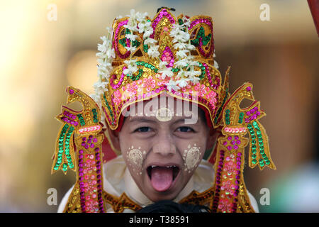 Yangon, Myanmar. 7 Apr, 2019. Ein kleiner Junge in traditionelle Kleidung besucht eine Parade während der Shinbyu novitiation Zeremonie an der Shwedagon Pagode in Yangon, Myanmar, April 7, 2019. Die Shinbyu novitiation Zeremonie ist ein wesentlicher Bestandteil im Leben eines Myanmar Buddhistischen männlichen unter dem Alter von 20 Jahren. Credit: U Aung/Xinhua/Alamy leben Nachrichten Stockfoto