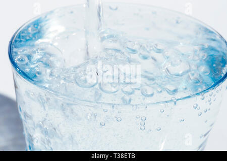 Wasser in das Glas gießen Stockfoto