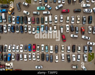 Ein Blick von Oben auf die Linien der geparkten Autos. Starker Verkehr auf dem Parkplatz. Auf der Suche nach Räumen in der geschäftigen Parkplatz. Kreuzfahrt für das Parken in der tun Stockfoto
