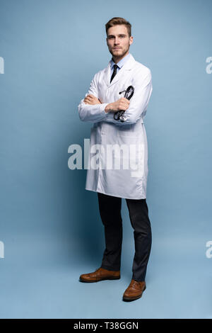 Volle Länge junge Arzt auf blauem Hintergrund. Stockfoto