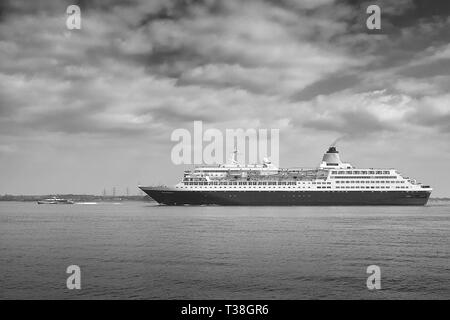 Schwarz-Weiß-Foto Der Saga Cruises (Saga Shipping), Kreuzfahrtschiff, Saga Sapphire, Nähert Sich Dem Hafen Von Southampton. Eine Schnellfähre fährt voraus. Stockfoto