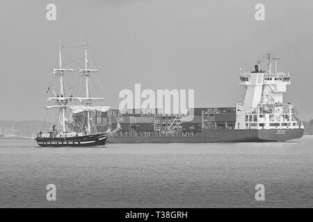 Schwarz-weiß Foto Der Schulschiff, TS ROYALISTISCHEN (Tall Ship), Abfahrt im Hafen von Southampton, leitet die eingehenden Containerschiff, Helga. Stockfoto