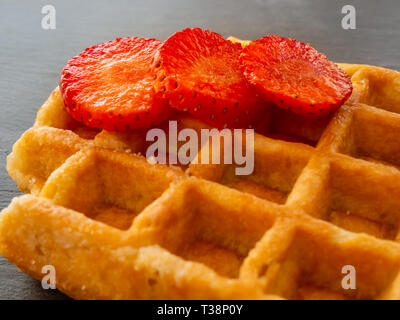 Eine belgische Waffeln mit Erdbeeren Stücke auf einem Schiefer Platte Stockfoto