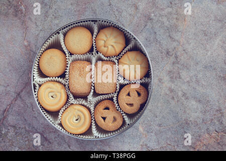 Cookies in einer Metalldose auf einem Marmor Hintergrund Stockfoto