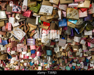 Köln, Deutschland, 6. April 2019. Unzählige bunte Vorhängeschlösser von Liebhabern auf einem Zaun auf der Hohenzollern Brücke links Stockfoto