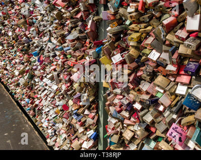 Köln, Deutschland, 6. April 2019. Unzählige bunte Vorhängeschlösser von Liebhabern auf einem Zaun auf der Hohenzollern Brücke links Stockfoto