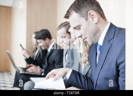 Bewerber vorbereiten für Beschäftigung Interview sitzen auf Stühlen in der Warteschlange Zeile line warten, Stellensuche Konzept Stockfoto