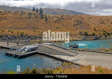 Radfahrer auf der Alpen 2 Ocean Cycle Trail Überqueren einer Wehr am Lake Ohau Stockfoto