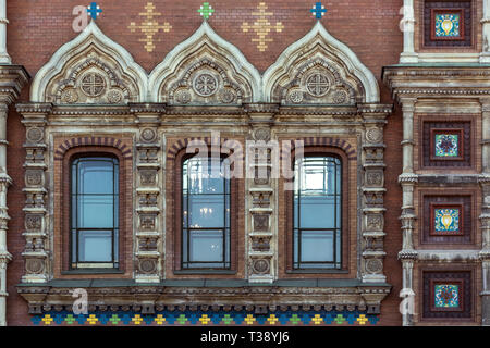 Drei Fenster mit dar, Stuck und malte auf dem Hintergrund einer Mauer in Rot. Aus einer Reihe von Windows von St. Petersburg. Stockfoto