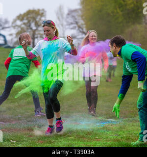 Junge Frau Runner in Farbe auf Macmillan Cancer Charity 5K Farbe Fun Run abgedeckt. Stockfoto