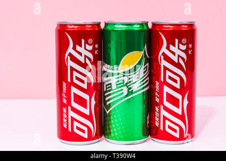 Peniscola, Castellon, Spanien - 07 April 2019: in der chinesischen zwei Dosen Coca-Cola geschrieben und man kann Getränke Sprite, isoliert auf eine rosa Farbe backgroun Stockfoto