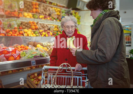 Junge Frau hilft, ältere Frau im Supermarkt Stockfoto