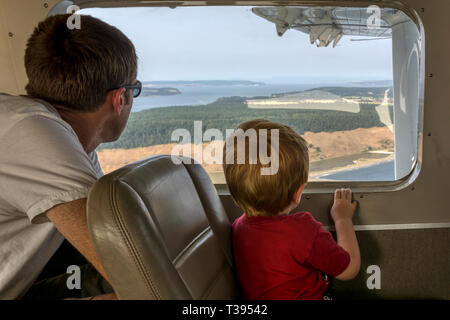 Ein Vater & Sohn Blick aus dem Fenster eines kleinen Wasserflugzeug zwischen Seattle und die San Juan Inseln fliegen. Stockfoto