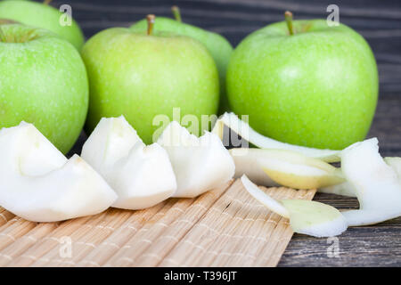 Die Küche Tisch beim Kochen eine Schale von Äpfeln Grün, und Teil der Apple ist in Scheiben geschnitten und geschält Stockfoto