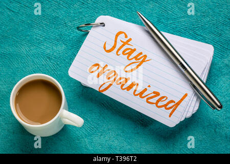 Bleiben Sie organisiert - Erinnerung an einen Stapel Karteikarten mit einer Tasse Kaffee Stockfoto