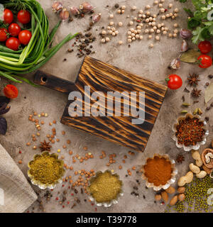 Frischem Gemüse und Tomaten Gewürze Getreide und Nüsse Bio gesunde Snacks auf einer strukturellen Hintergrund. Konzept der gesunden Ernährung. Rahmen unter dem Text. Stockfoto