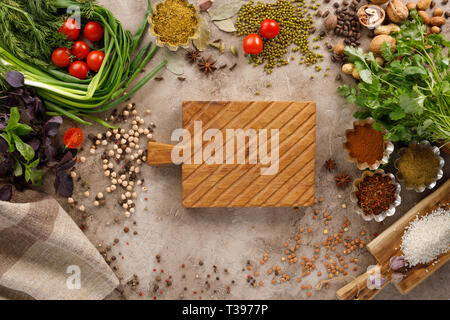 Frischem Gemüse und Tomaten Gewürze Getreide und Nüsse Bio gesunde Snacks auf einer strukturellen Hintergrund. Konzept der gesunden Ernährung. Rahmen unter dem Text. Stockfoto