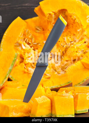 In Scheiben geschnittene und andere Formen der Reife orange Kürbis beim Kochen und Essen, Nahaufnahme in der Küche Stockfoto