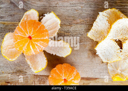 Mandarin liegen auf einem alten hölzernen Schneidebrett geschält Stockfoto