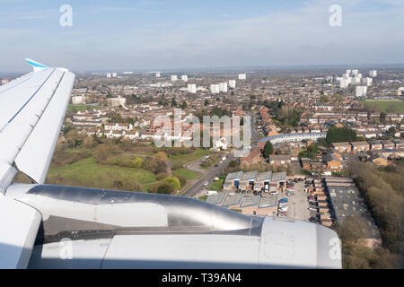 Ein Luftbild über Birmingham und eines Flügels und Triebwerks eines Verkehrsflugzeugs, wenn ein Passagierjet auf dem internationalen Flughafen von Birmingham landet Stockfoto