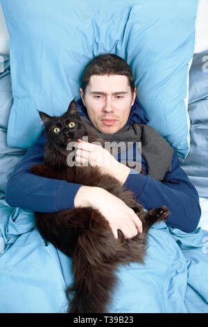 Foto von Kranken Schal mit Katze im Bett lag, Stockfoto