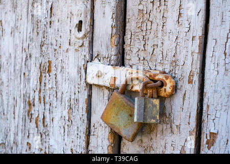 Rostige alte Schlösser auf einer alten hölzernen Tor Stockfoto
