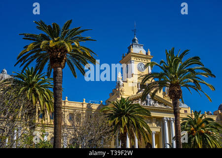 Fassade des Stadtrates in Malaga mit grünen Palmen, Spanien. Dieses Gebäude, 1919 erbaut, ist seit 2010 als Teil des Erbes der kulturellen Inte aufgeführt Stockfoto