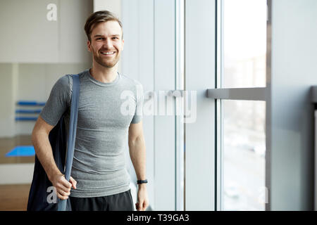 Freundliche Mann mit Yogamatte Stockfoto