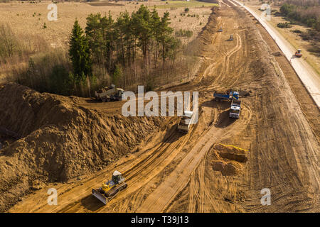 Drone Ansicht von Lkw, Bulldozer und Straße Reparaturarbeiten in ländlichen Landschaft. Drone Fotografie. Stockfoto