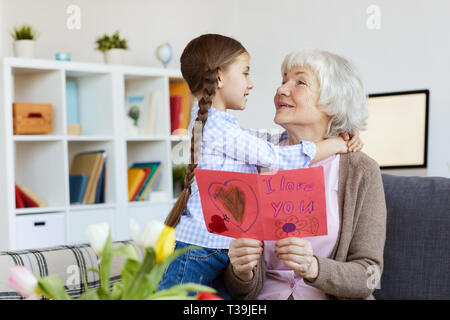 Ältere Frau umarmt Cute Girl Stockfoto